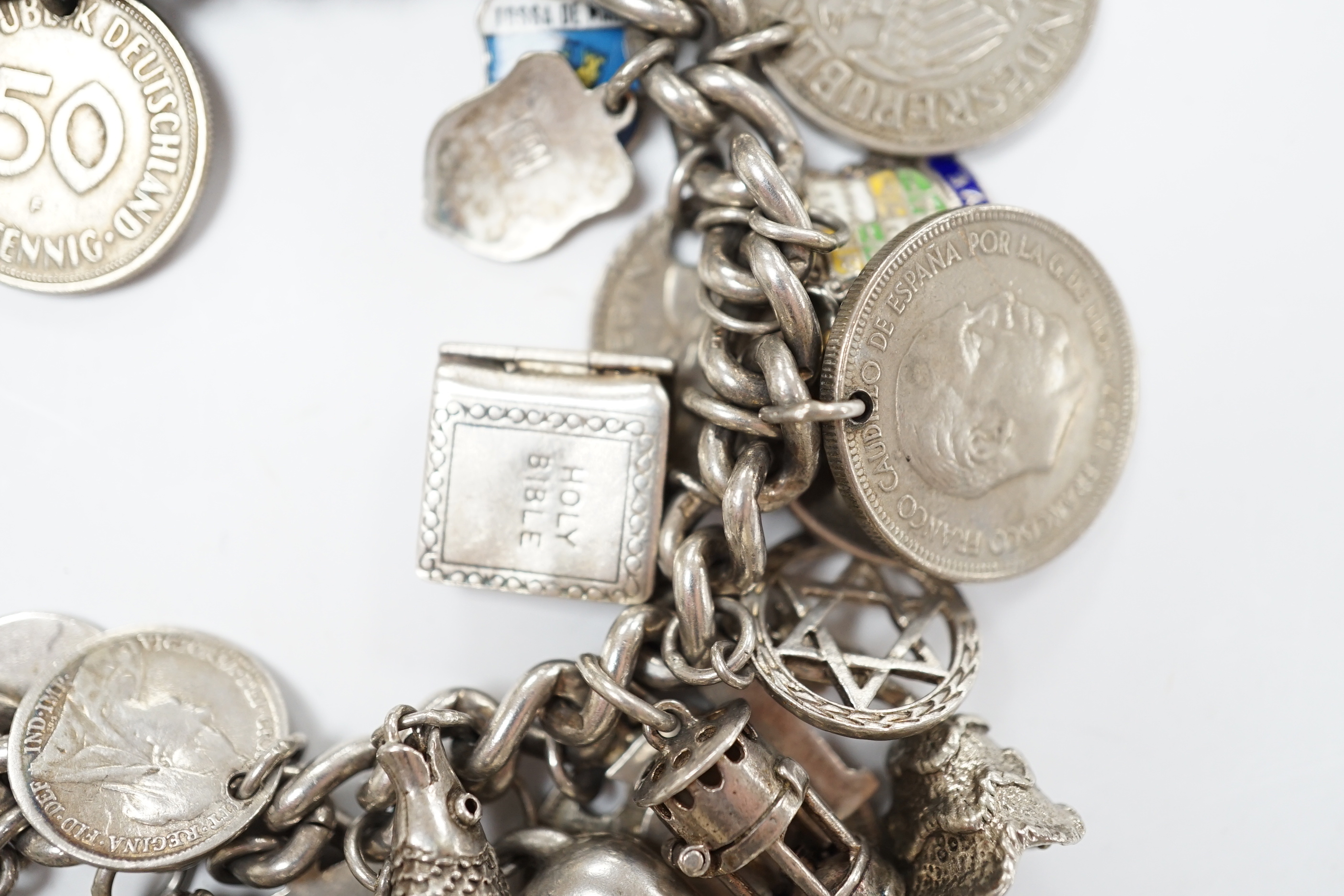 A silver charm bracelet, hung with assorted mainly white metal charms including tankard and Knight's helmet, two 'melted' ingots and a silver medallion.